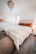 Elegant solid wood bed with soft bedding in a serene bedroom.