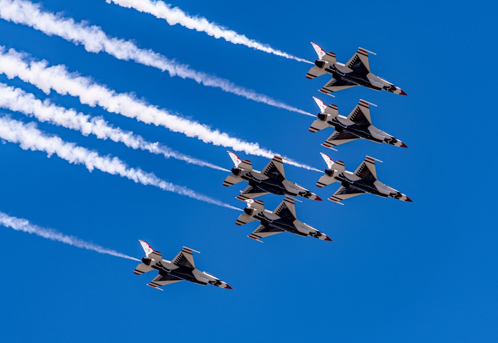 four fighter planes flying in the sky during daytime