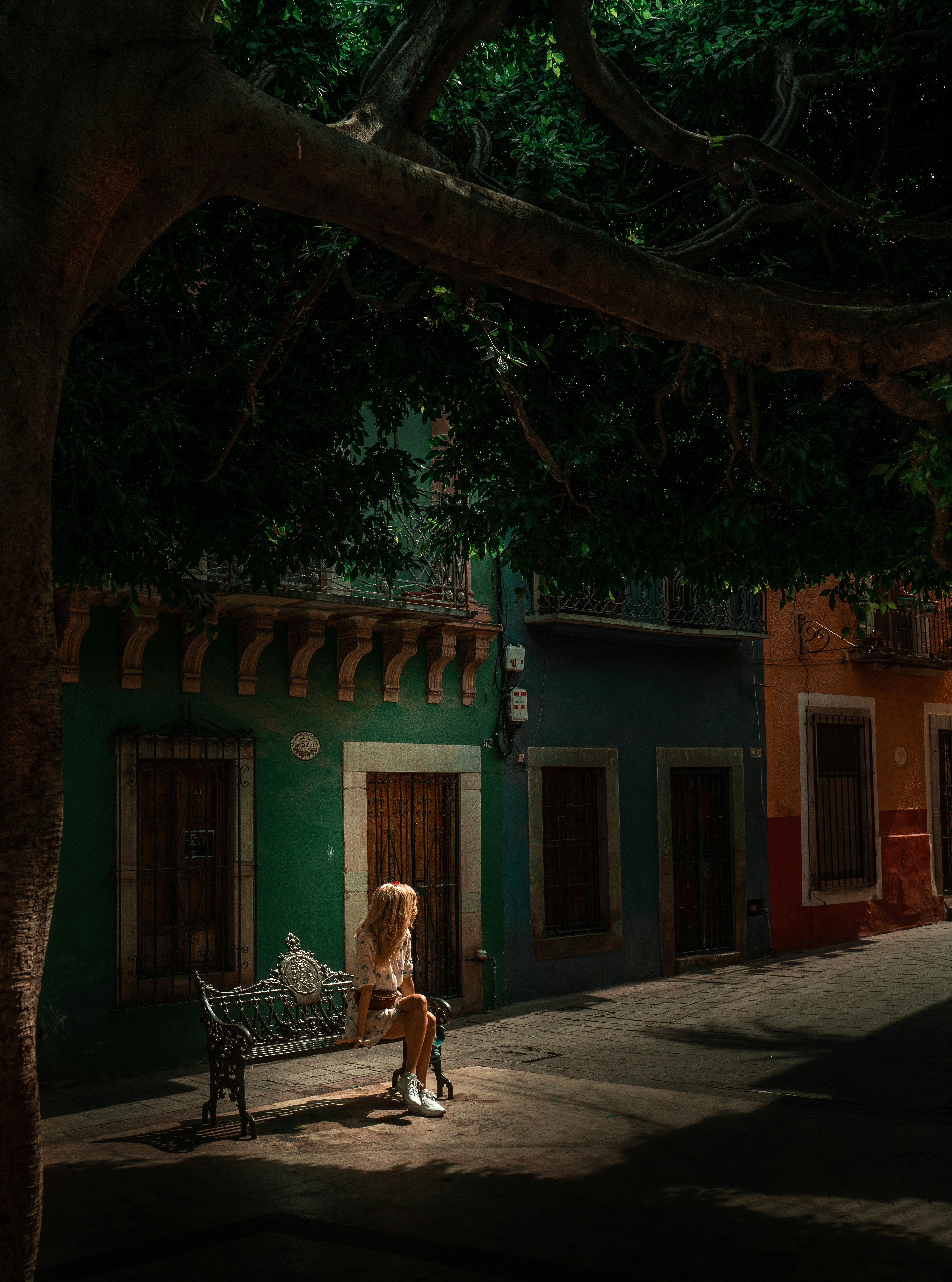 woman in brown coat walking on sidewalk during daytime