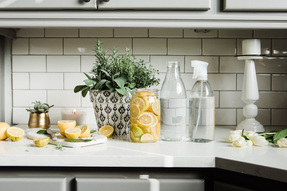 bouteilles en verre transparent sur table blanche