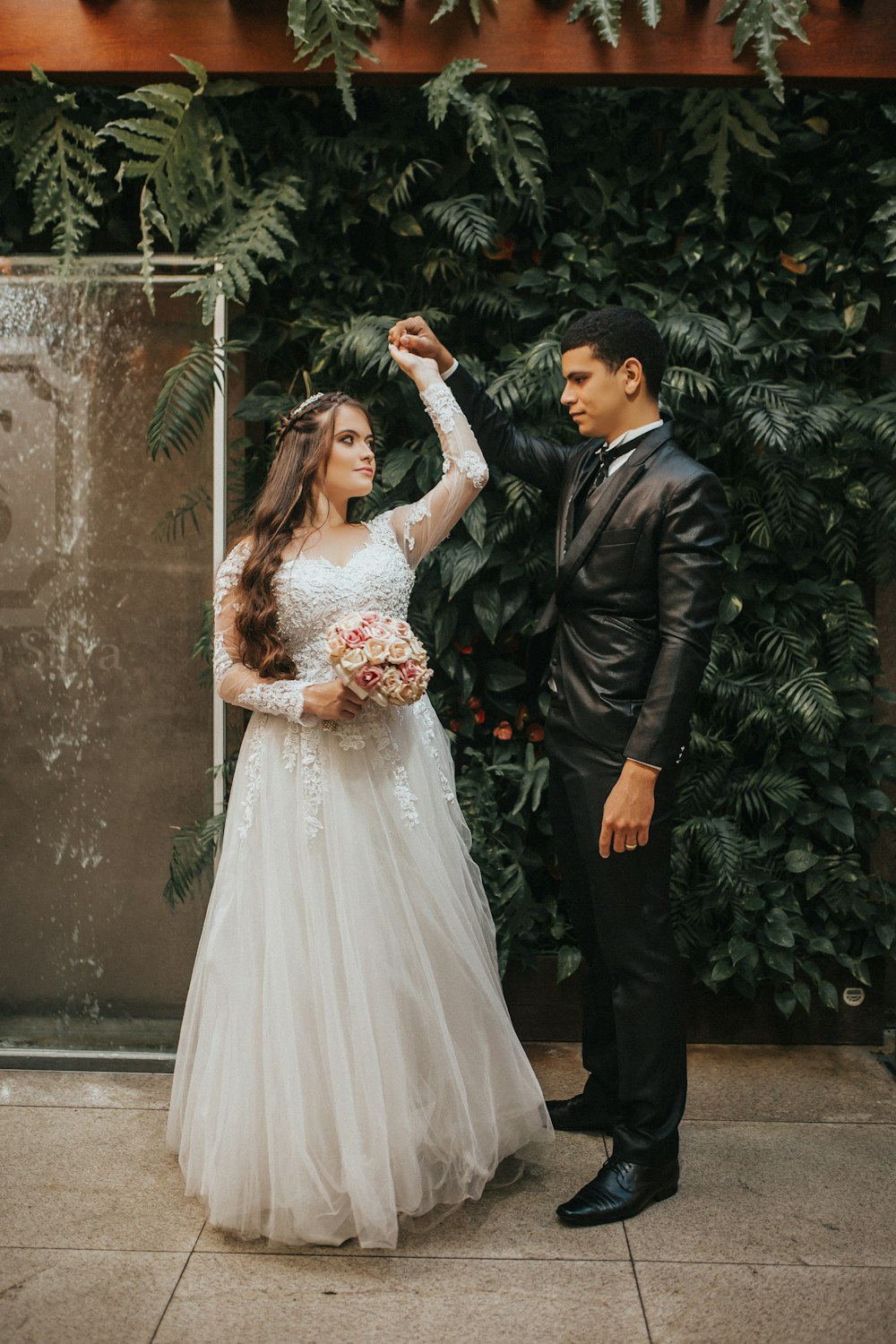 man in black suit jacket holding woman in white wedding dress