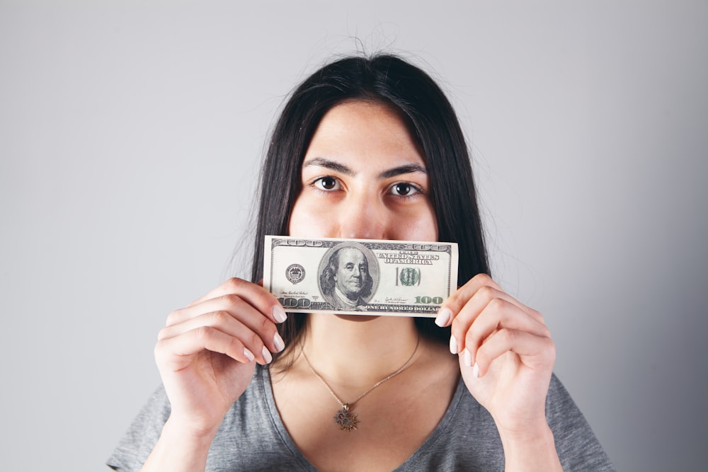 woman holding a 1 us dollar bill