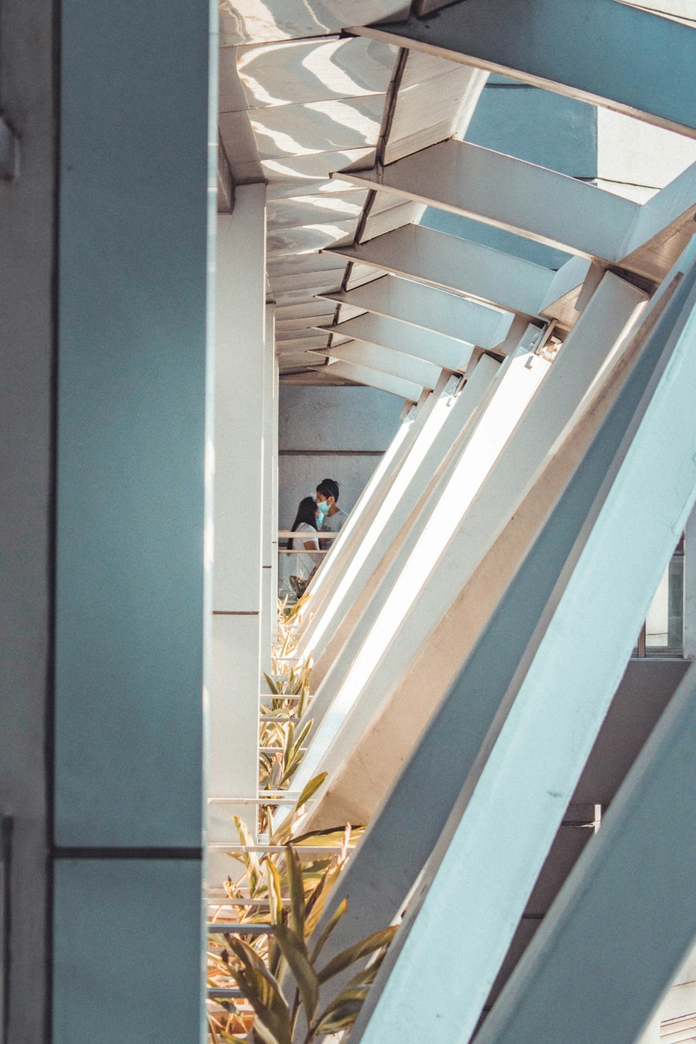 man in black jacket and blue denim jeans standing on white staircase