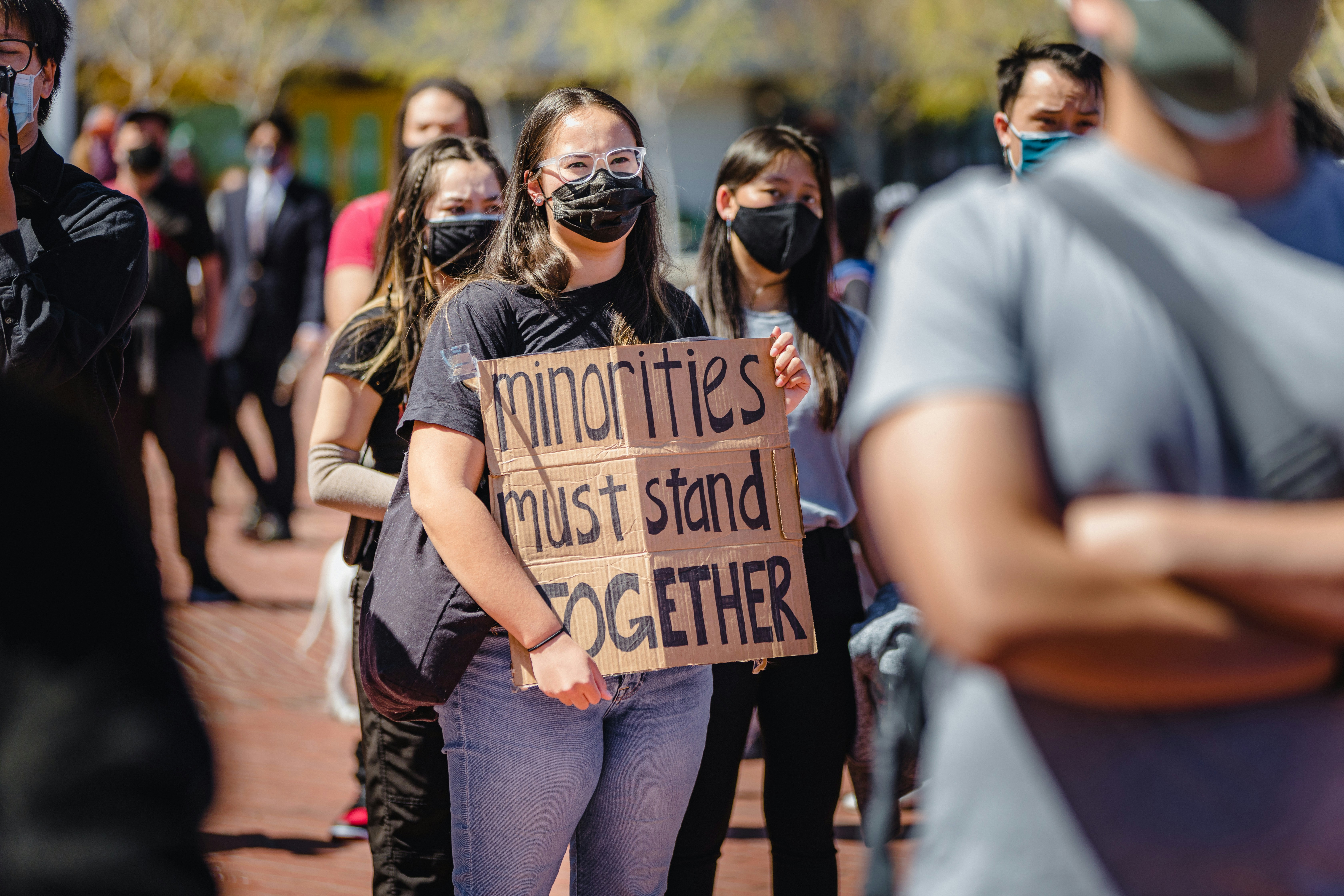 A group of people standing around each other holding a sign photo ...