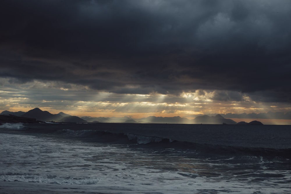 sea waves crashing on shore during sunset