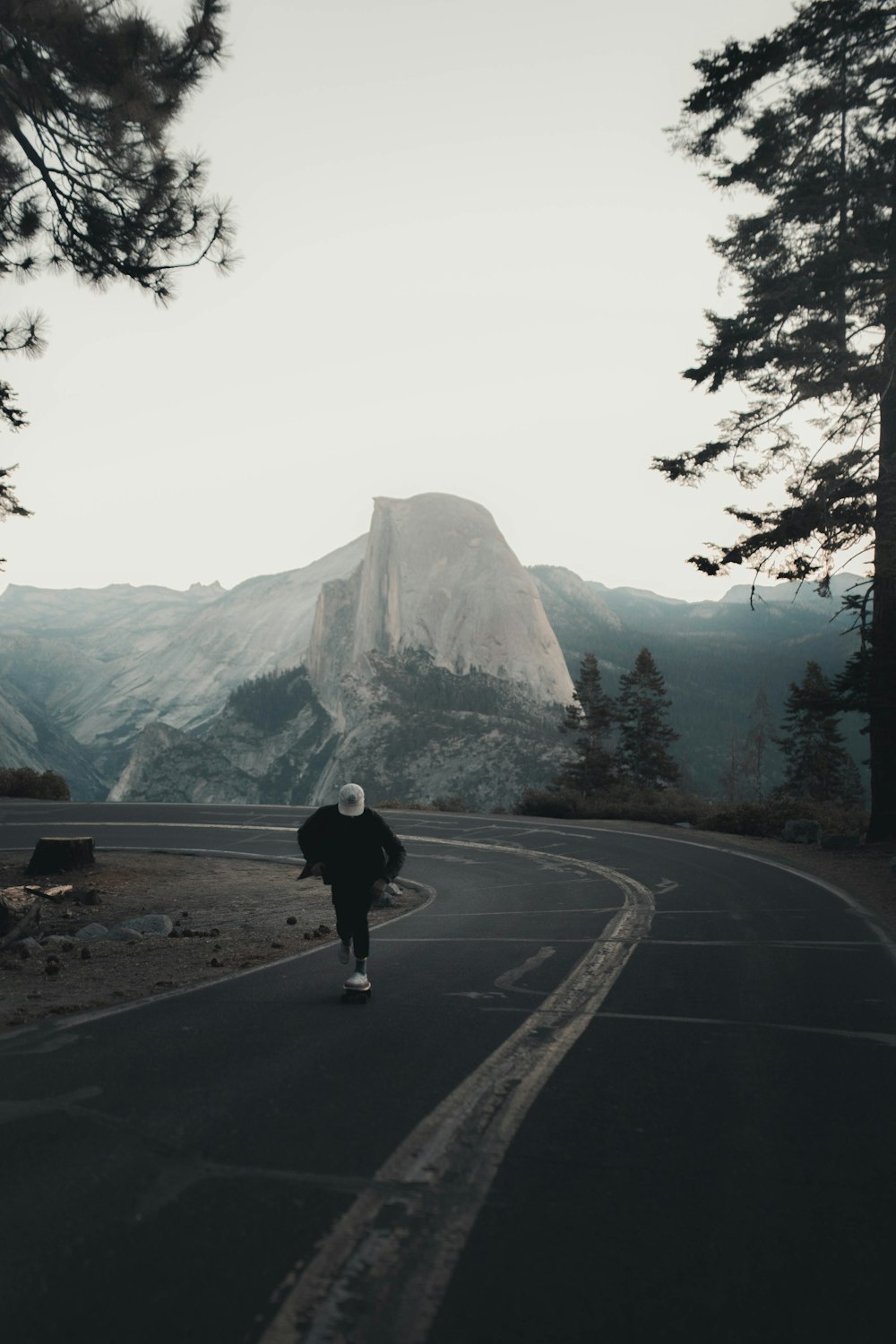 person in black jacket walking on road during daytime