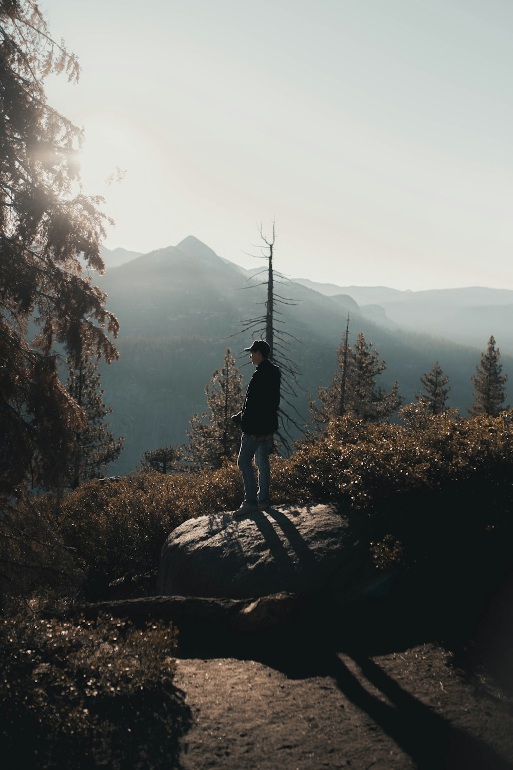 woman in black jacket standing on rock during daytime