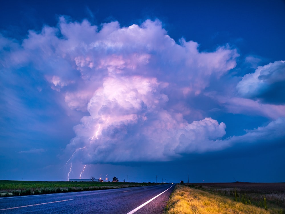 graue Asphaltstraße unter weißen Wolken und blauem Himmel tagsüber