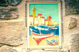 Colorful mural celebrating Sardinian culture painted by local youth in a village square.
