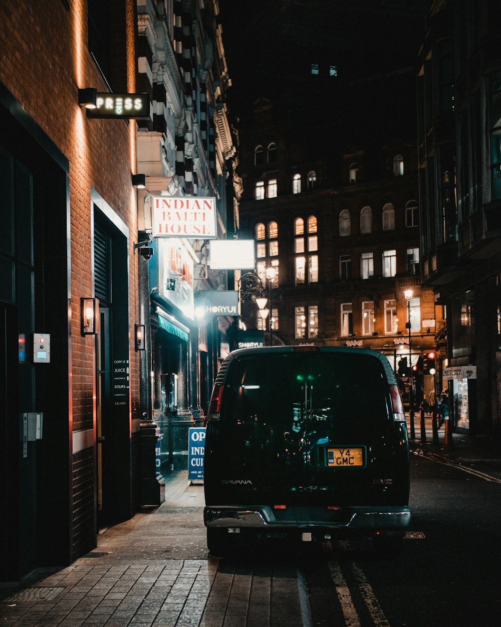 black car parked beside building during night time