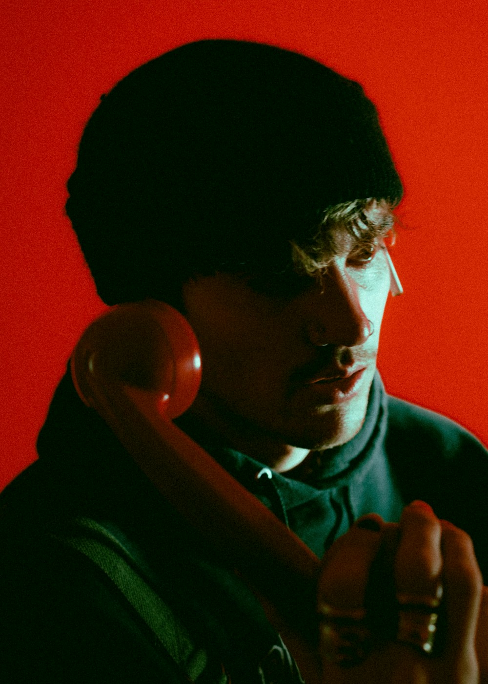 man in black hoodie holding smartphone