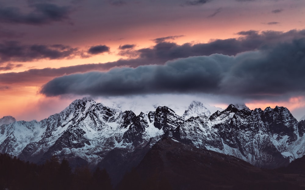 snow covered mountain under cloudy sky during daytime