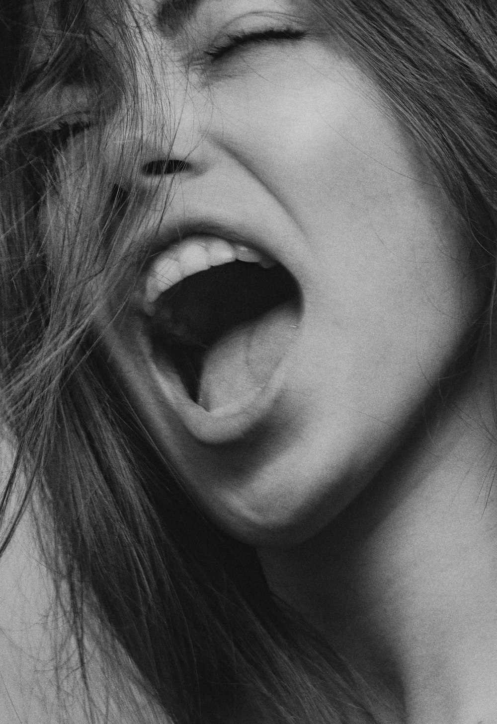 foto in scala di grigi della bocca della donna