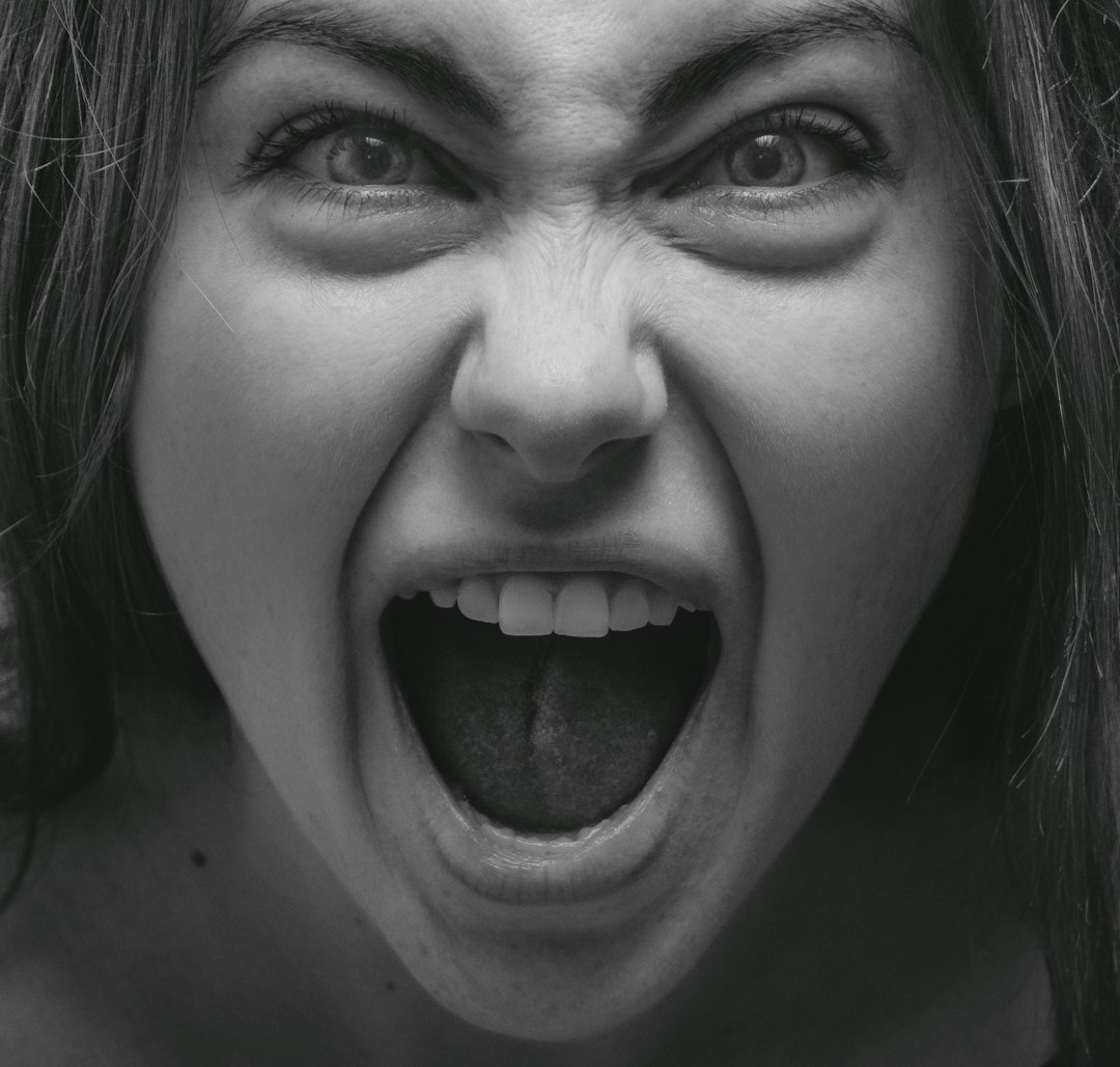 grayscale photo of woman showing her tongue