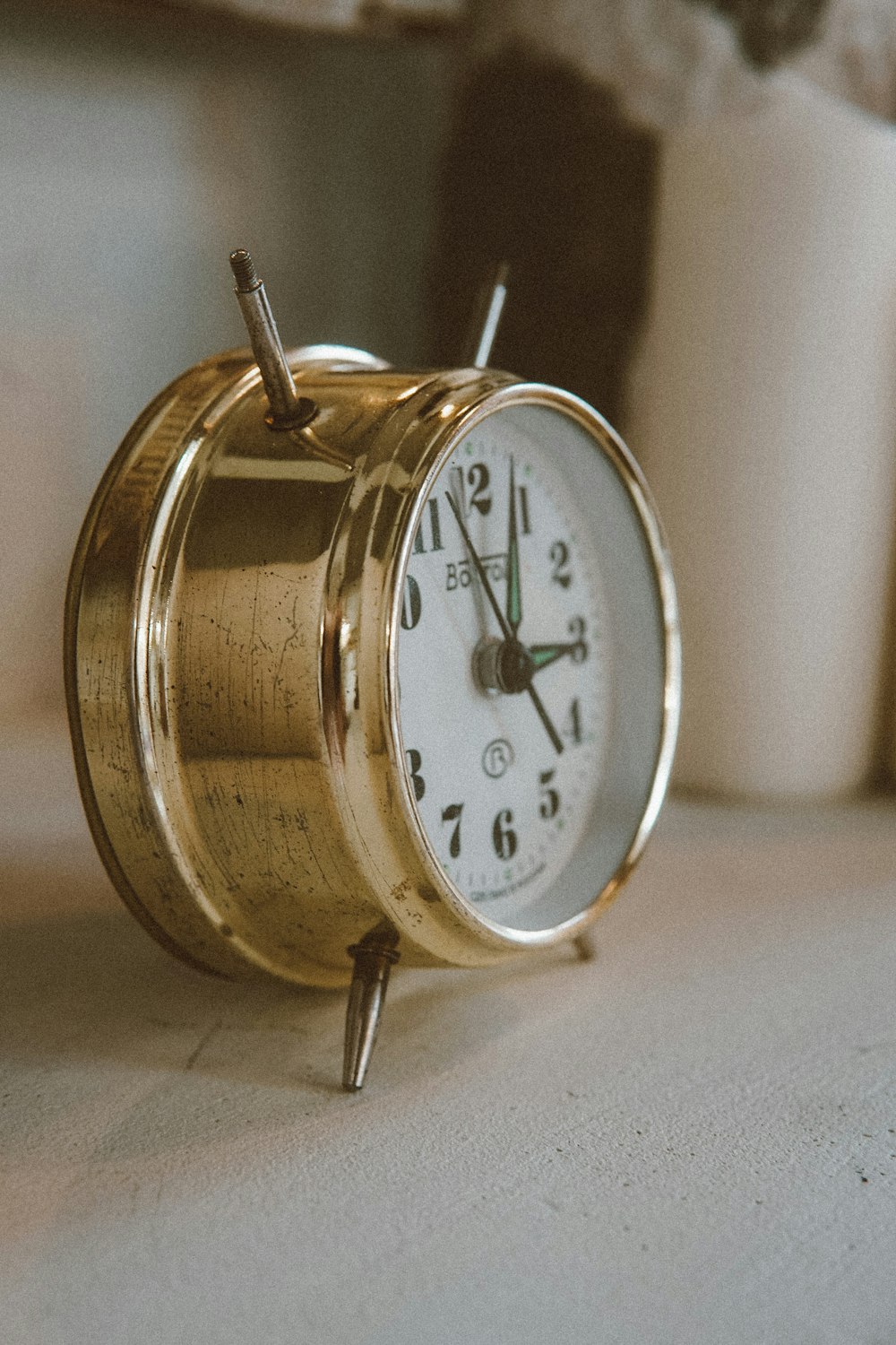 gold and white analog alarm clock