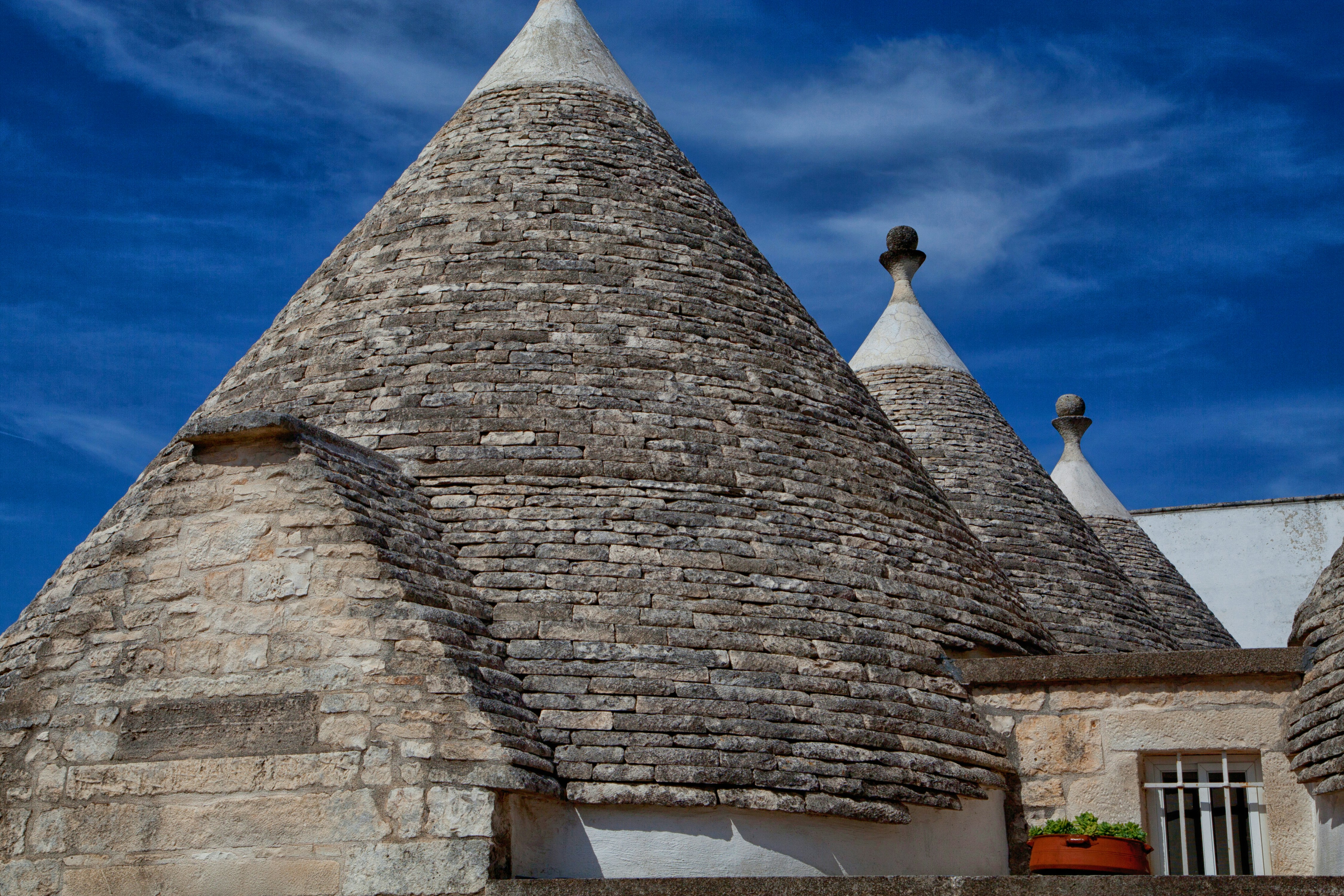 brown brick tower under blue sky during daytime, stone houses under blue sky