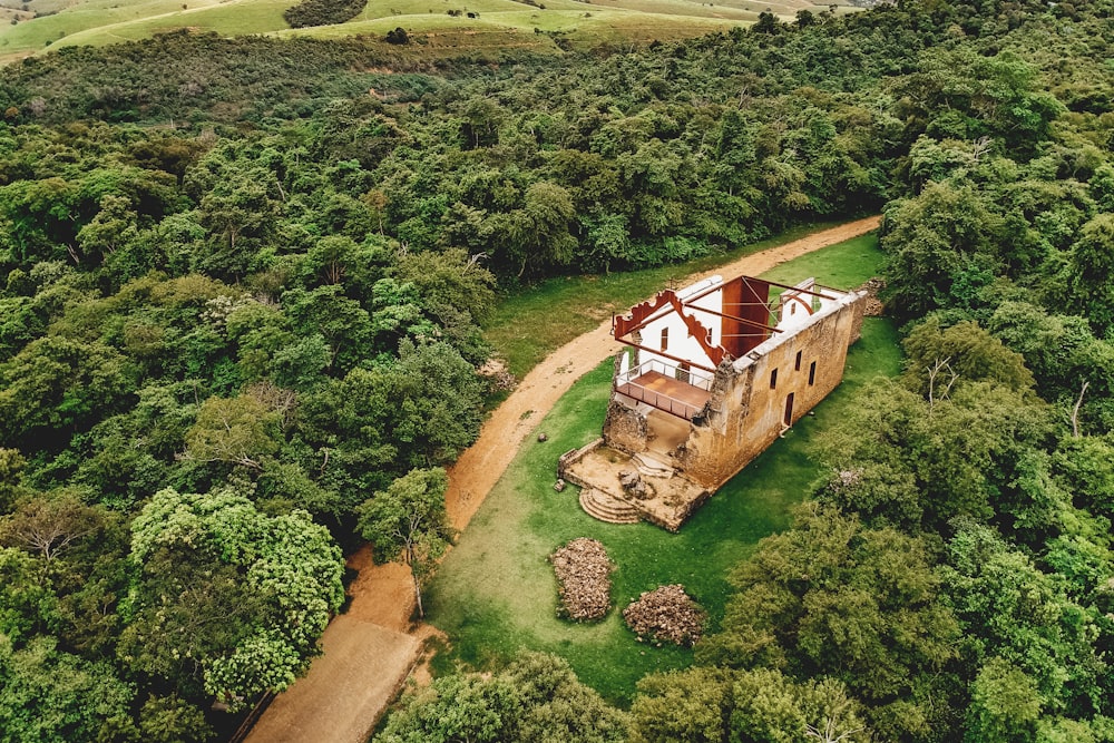 maison en bois marron et blanc sur un champ d’herbe verte pendant la journée