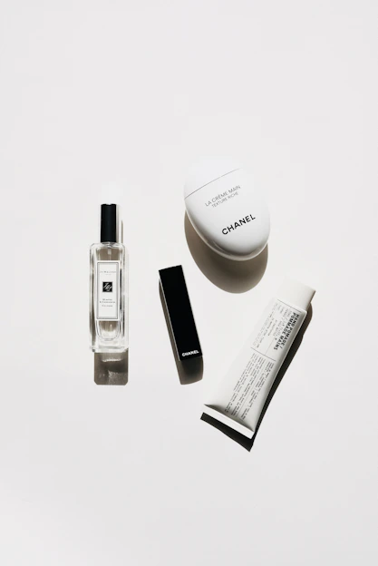 A serene, minimalist flat lay of Izil Cosmetics products with soft gold accents on a cream background, highlighting luxury and simplicity.