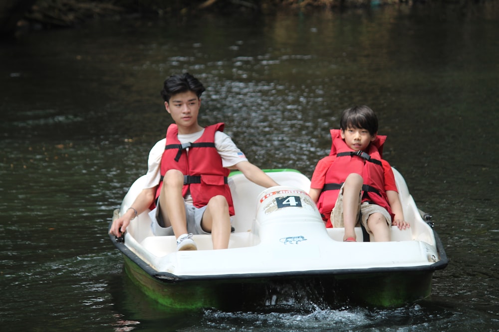 man in red vest riding white and red kayak