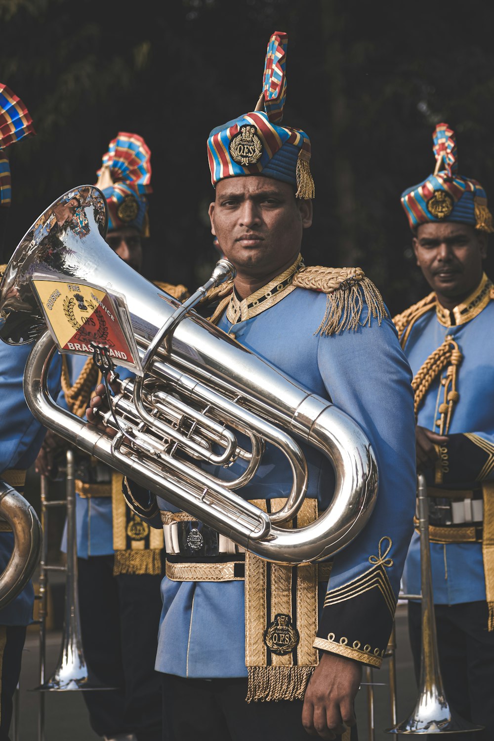 Hombre en oro y sombrero azul tocando la trompeta