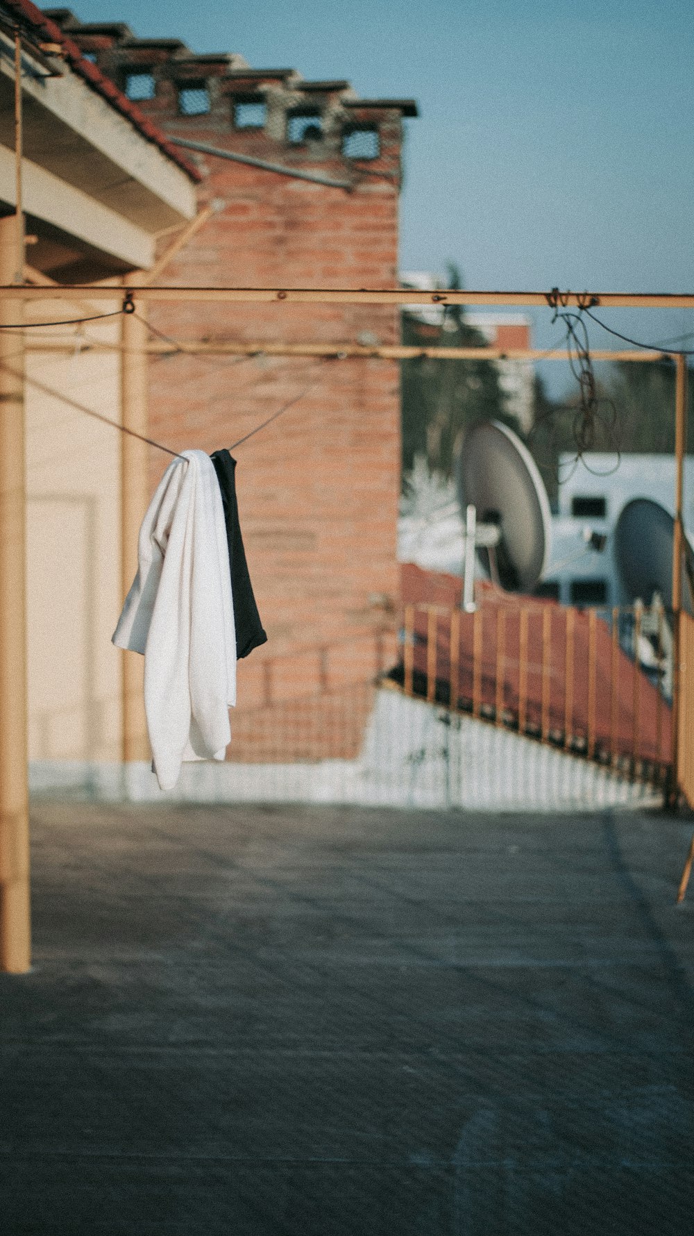white textile hanging on brown wooden fence