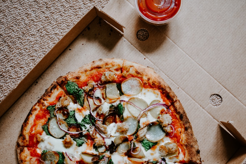 pizza with green and red vegetables on brown wooden table