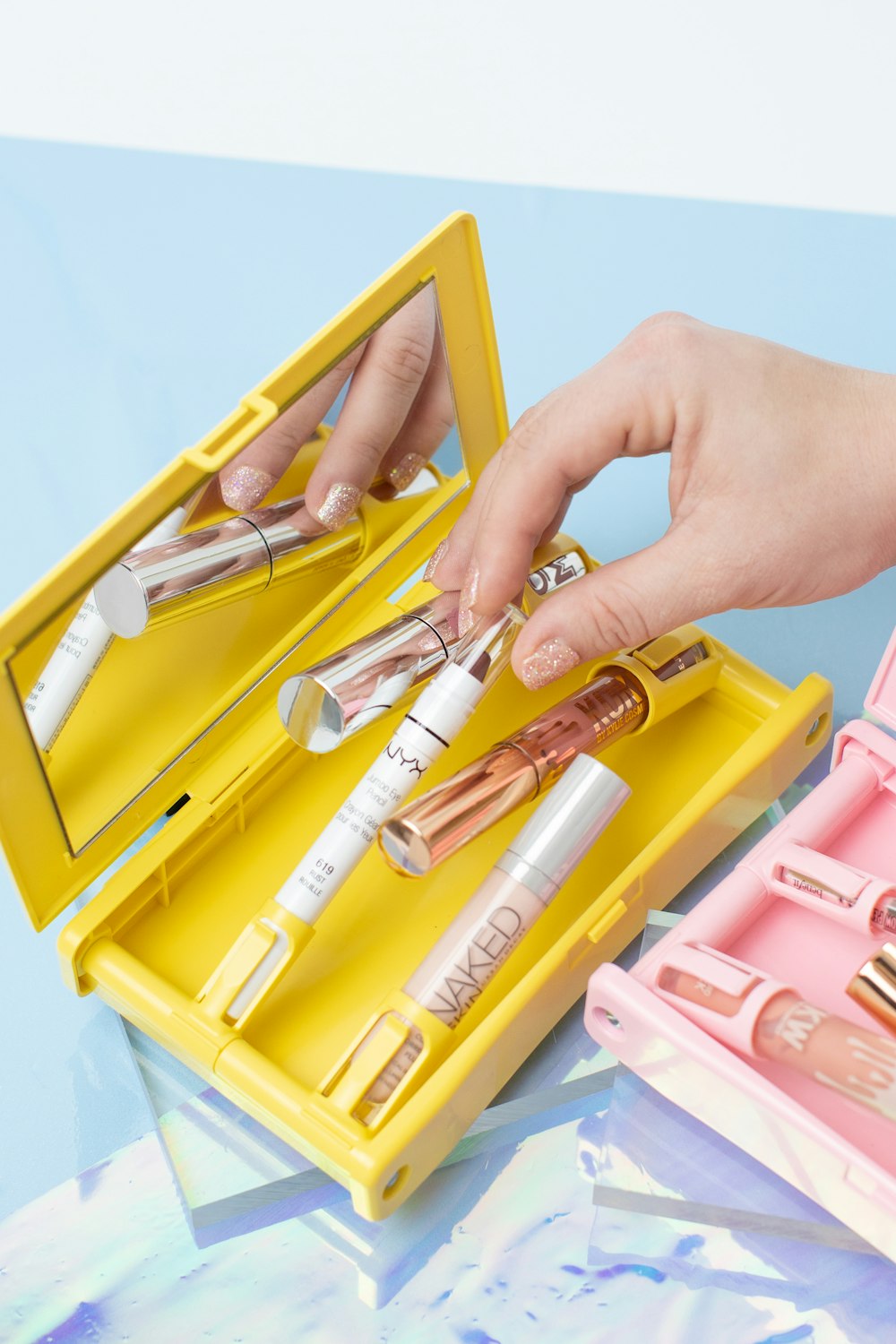 person holding yellow and pink plastic container