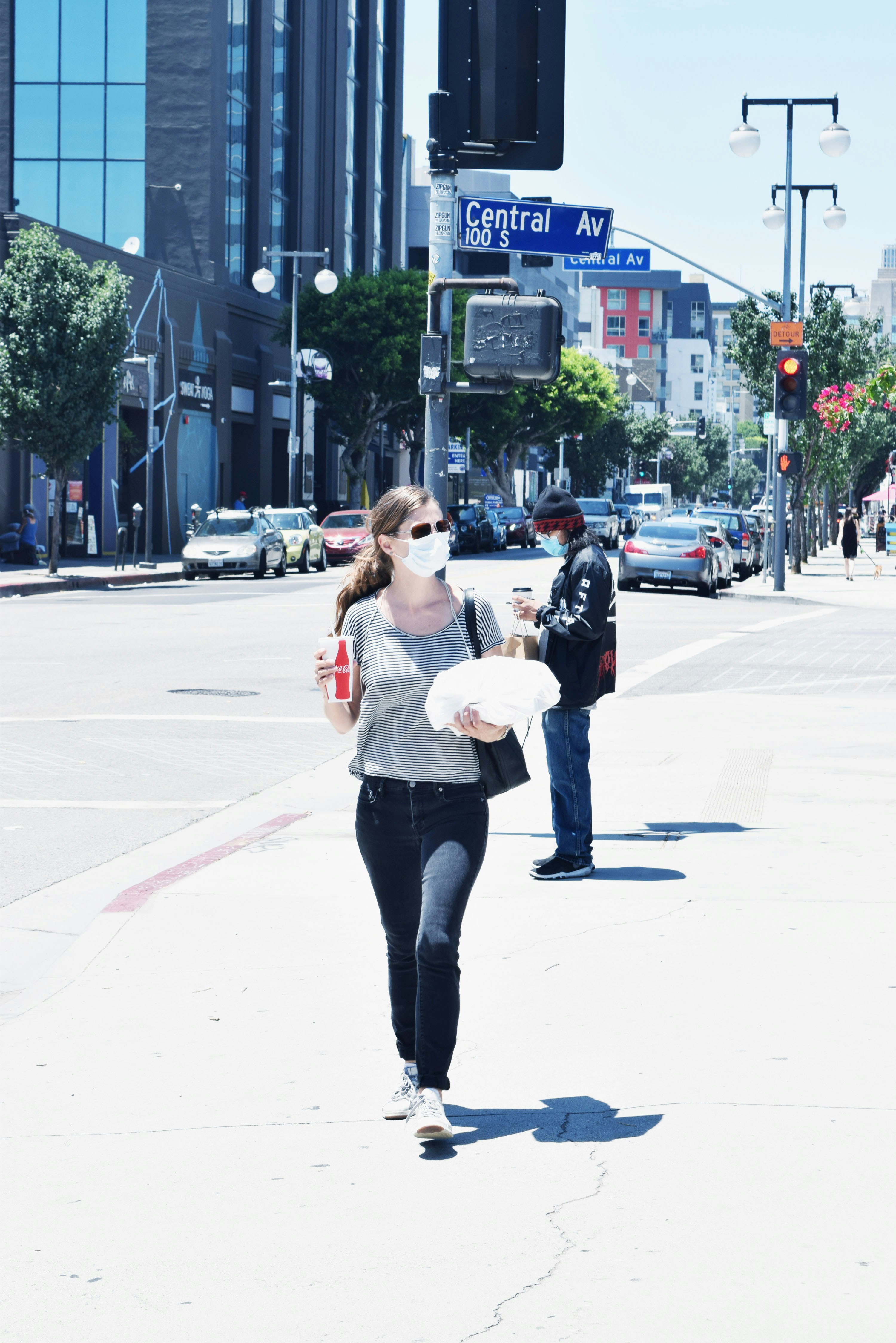 woman in white long sleeve shirt and black pants standing on road during daytime