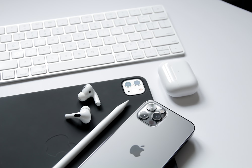 apple earpods and silver iphone 6 on apple keyboard
