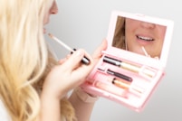 woman holding pink and white makeup box
