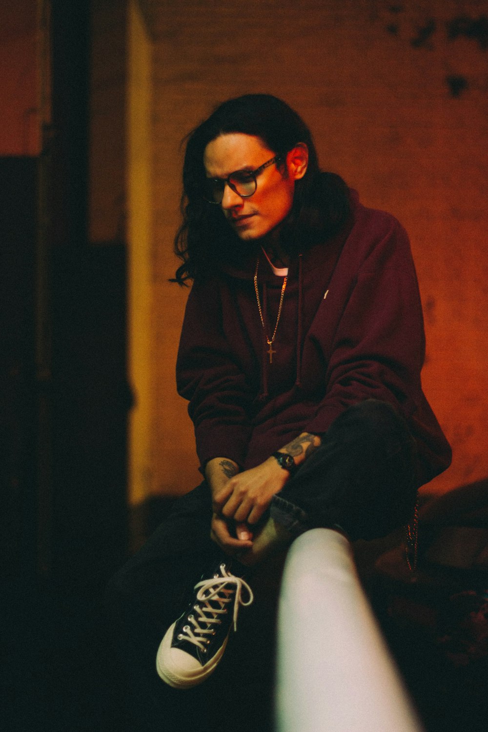 man in brown zip up jacket and black pants sitting on brown wooden chair