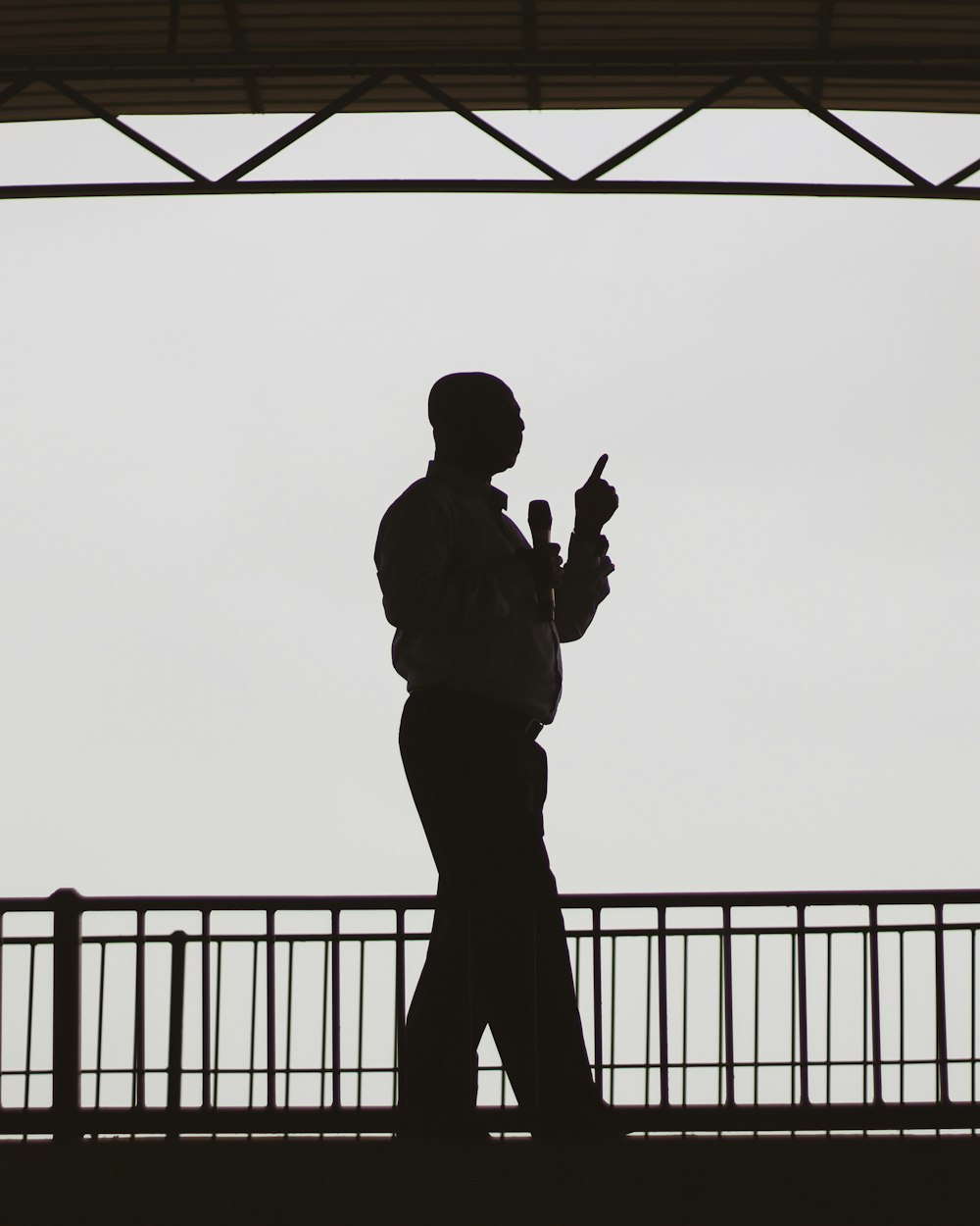 silhouette d’homme debout près de la clôture pendant la journée