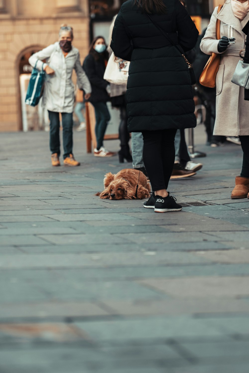 person in black coat walking on sidewalk during daytime