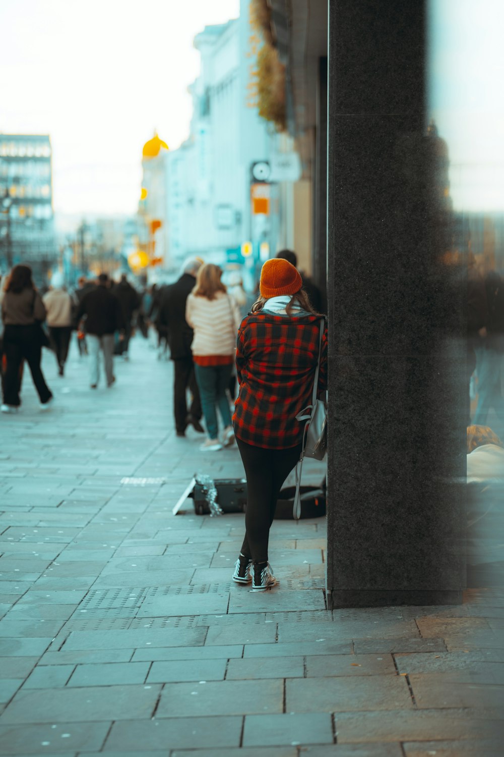 mulher em vermelho branco e preto listrado camisa de manga comprida andando na calçada durante o dia