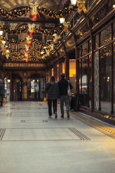 man in black jacket walking on sidewalk during nighttime