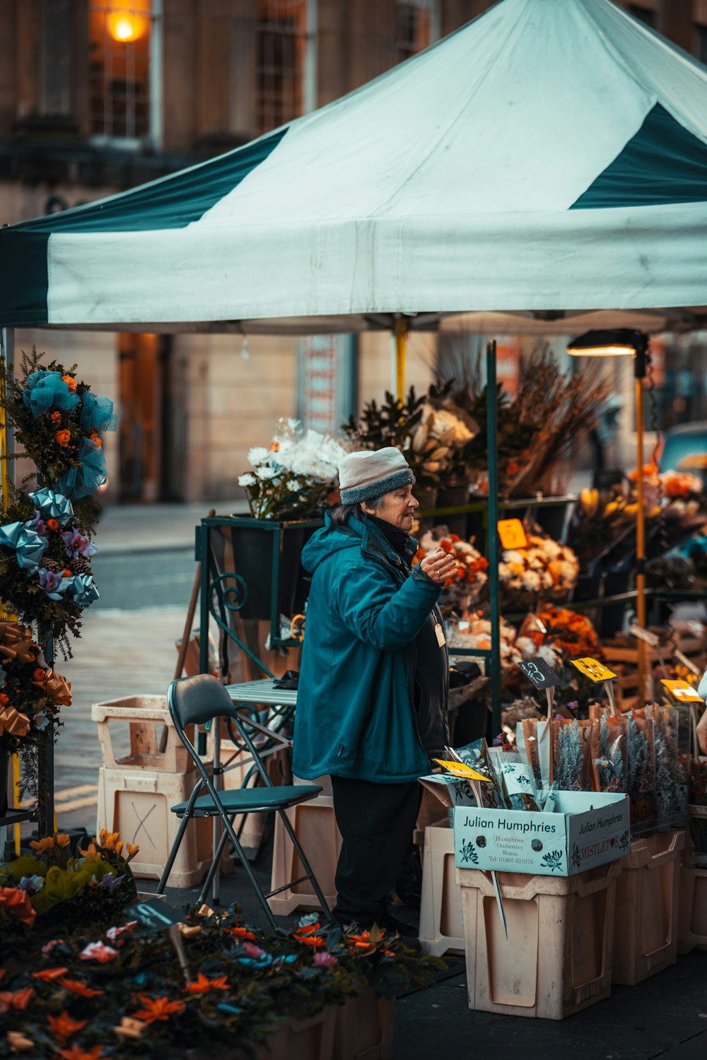 woman in green coat standing near brown wooden table