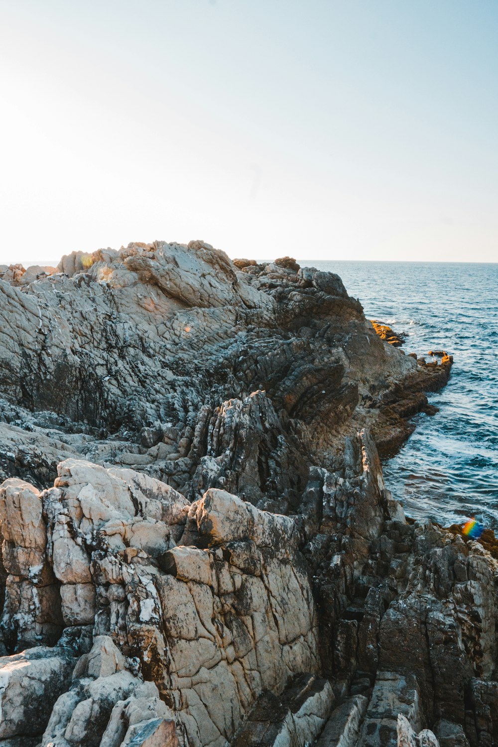 brown rock formation near body of water during daytime