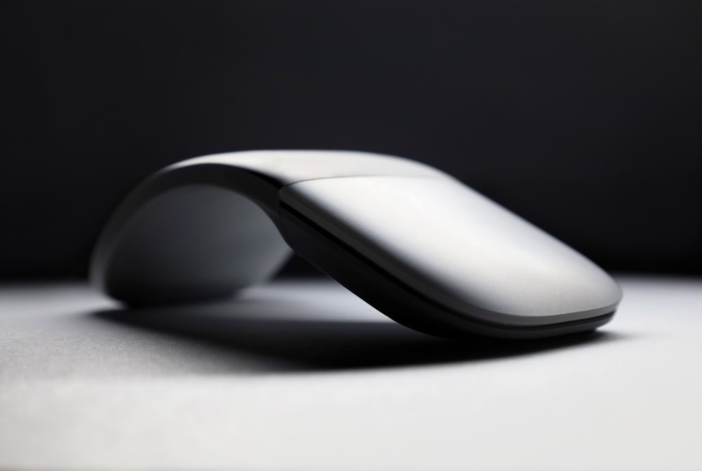 white cordless computer mouse on white surface