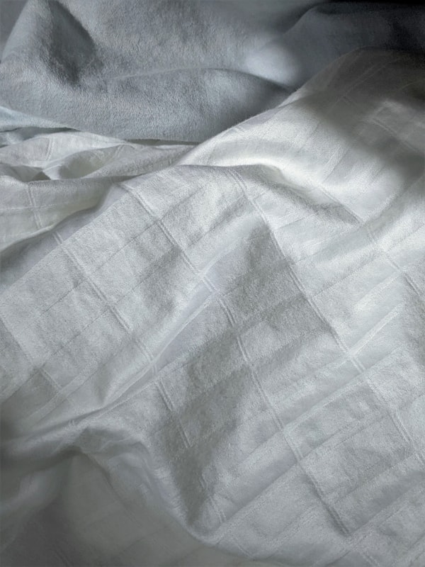 Bed styled with white and blue coordinated bed linen set