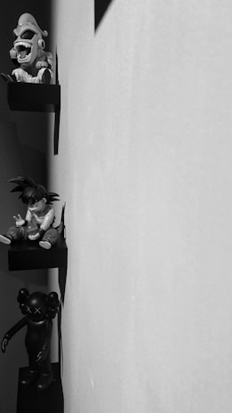 Decorative 3D printed figurines arranged on a wooden shelf, highlighting intricate details and textures.