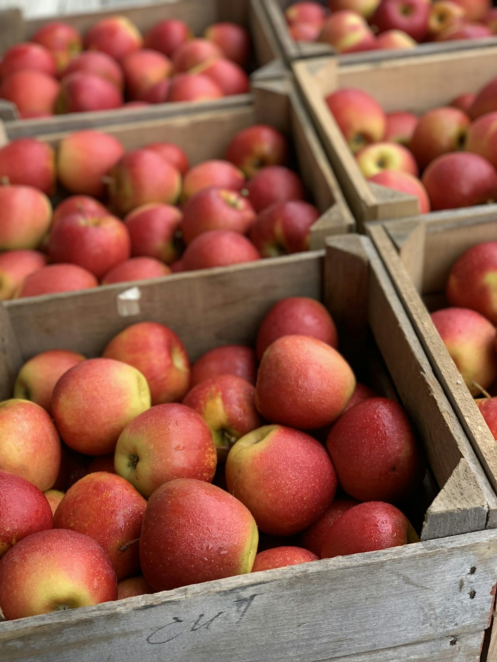 pommes rouges sur caisse en bois brun