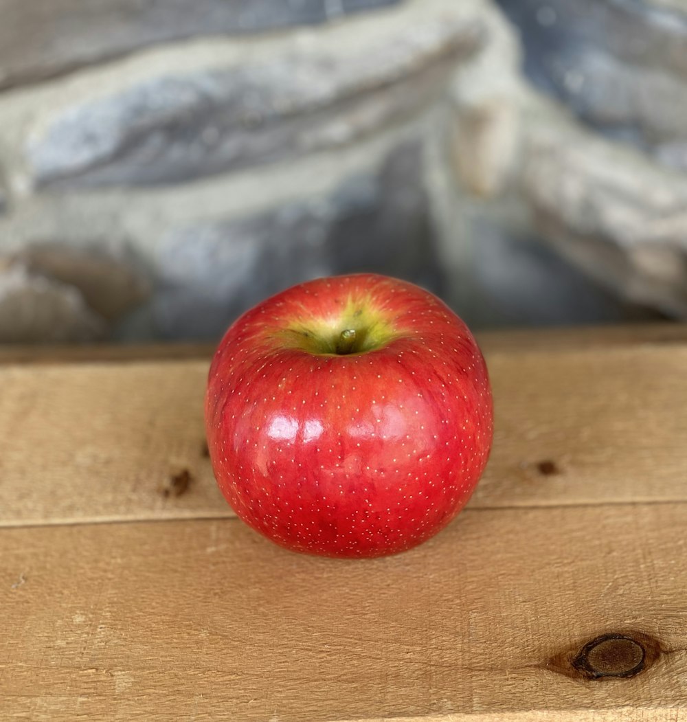 rote Apfelfrucht auf braunem Holztisch