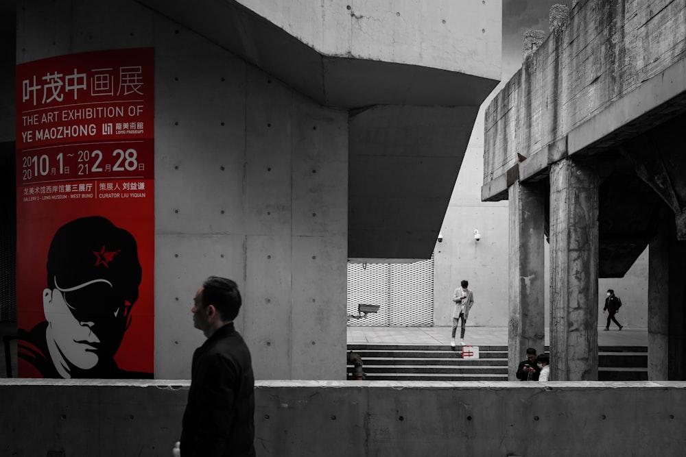 man in black jacket walking on sidewalk during daytime