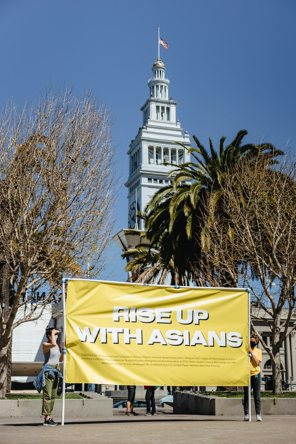 a group of people standing next to a yellow sign