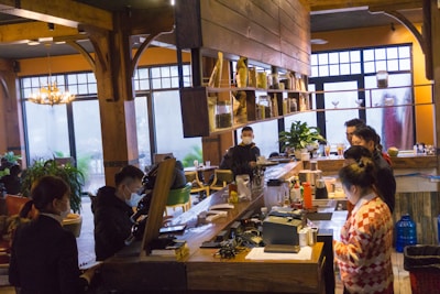 Waiters and bartenders serving customers in a cozy café setting.