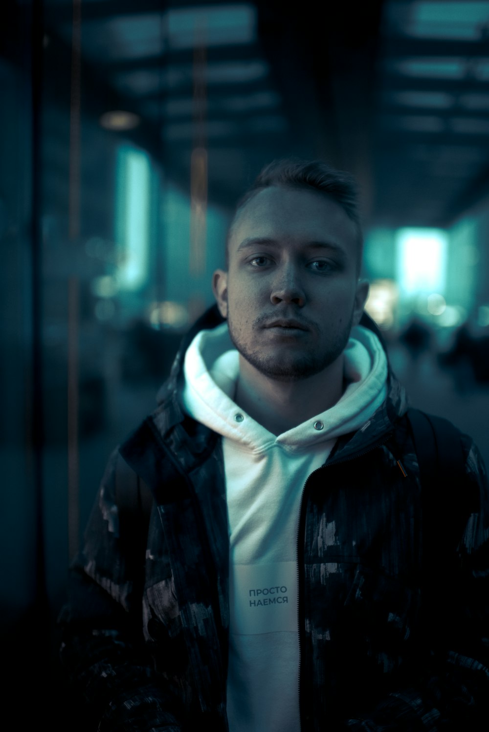 man in black jacket standing near building during night time