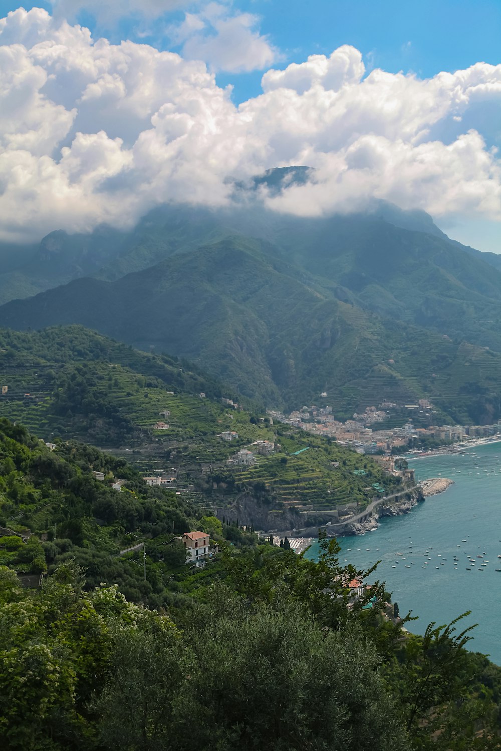 green mountains beside body of water under cloudy sky during daytime