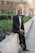 man in black suit jacket and black pants standing on pathway