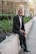 man in black suit jacket and black pants standing on pathway