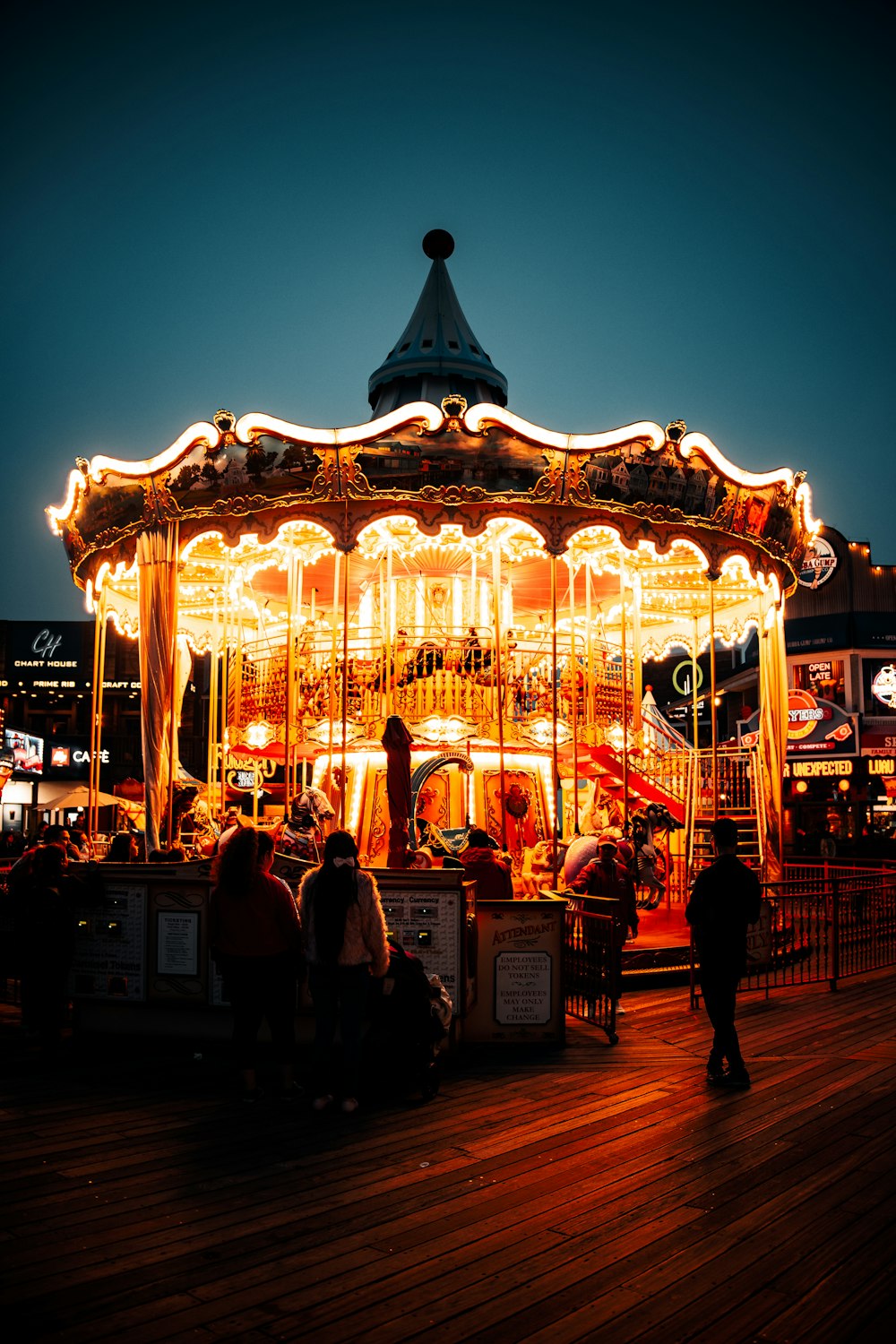 les personnes debout près du carrousel éclairé pendant la nuit